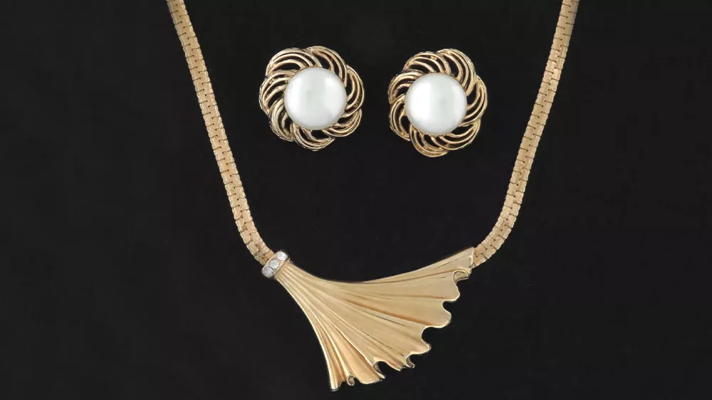 ست Michele Deco شامل گوشواره با نگین سفید و گردنبند روی زمینه مشکی