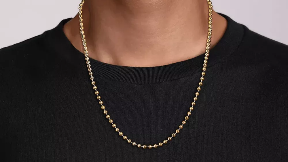زنجیر Gabriel 14K Yellow Gold Faceted Chain در گردن مردی با تیشرت مشکی