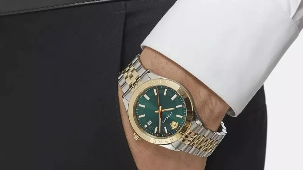 ساعت طلا مردانه ورساچه با صفحه سبز رنگ روی دستی که در جیب شلوار قرار گرفته