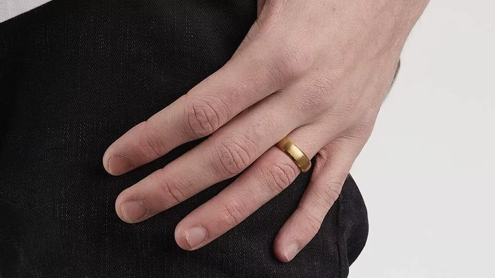 انگشتر Gold Titanium Steel Band در دست مردی با شلوار مشکی