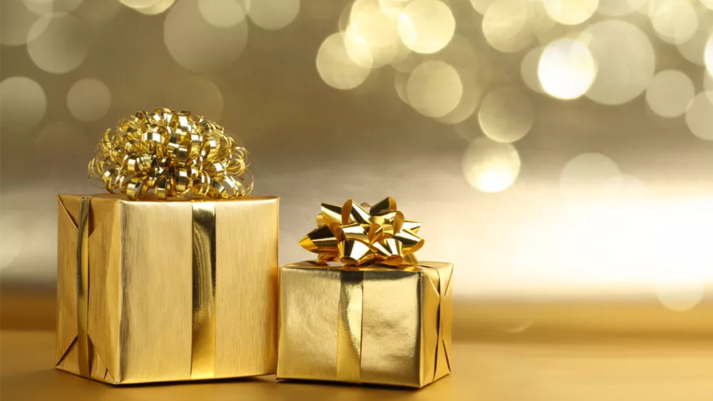 دو جعبه با کاغذ کادوی طلایی رنگ و پسزمینه با تم رنگ طلایی