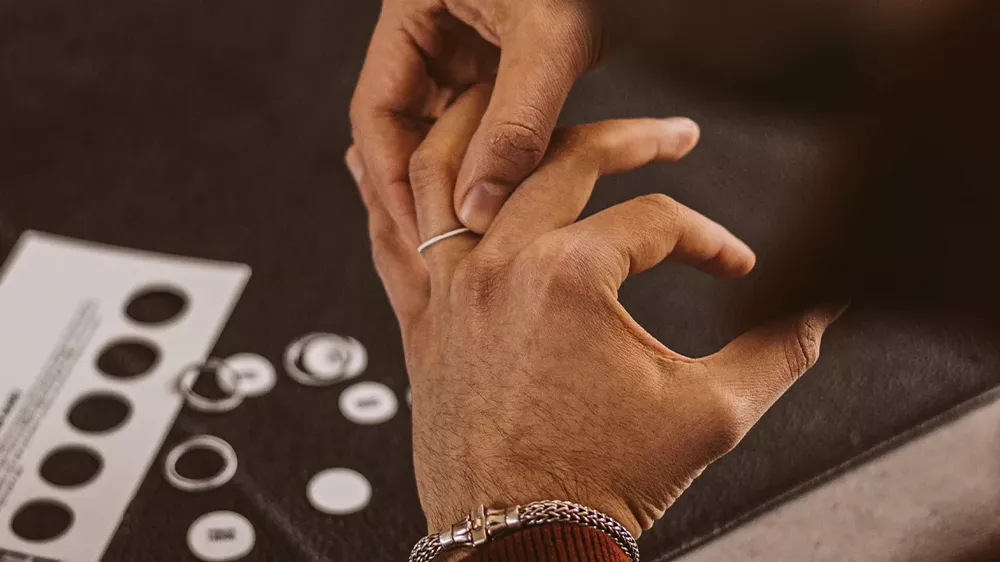 یک مرد در حال قرار دادن انگشتر در دست چپ