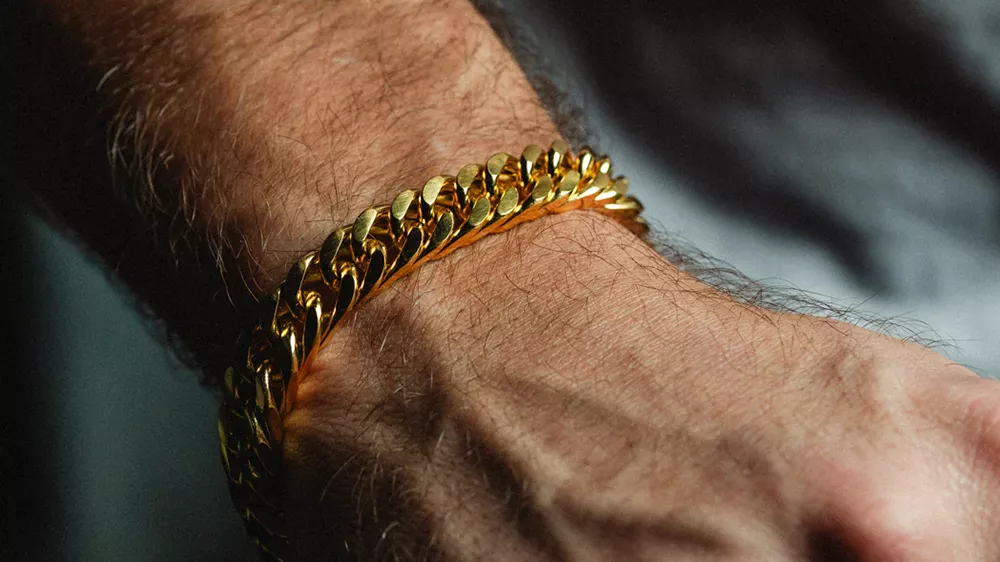 دستبند طلا مردانه کیوبن لینک روی دست یک مرد