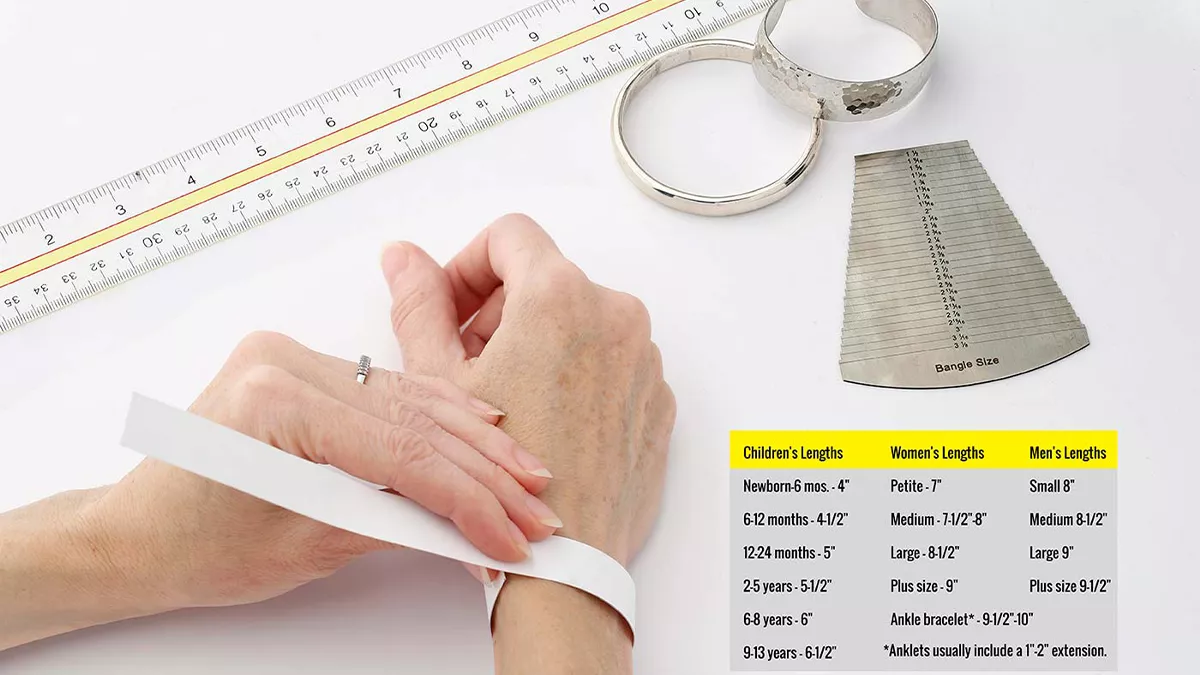 یک خط کش، دو دستبند و فردی که در حال اندازه‌گیری سایز مچ دست با کاغذ است