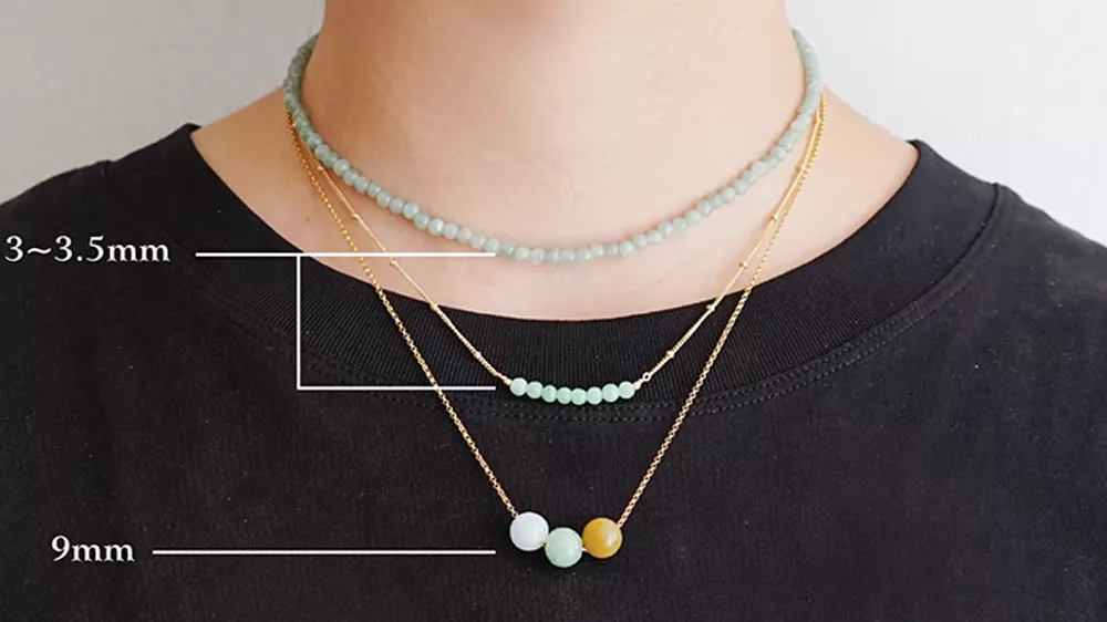 ۳ زنجیر با سایزها و طرحهای متفاوت در گردن مردی با تیشرت مشکی